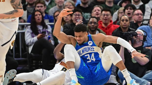 Milwaukee Bucks forward Giannis Antetokounmpo (34) falls after colliding with Denver Nuggets forward Peyton Watson (8)